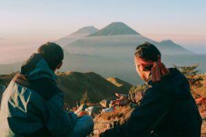 One on one meeting with an employee during a mountain trip. Two men looking at a volcano.