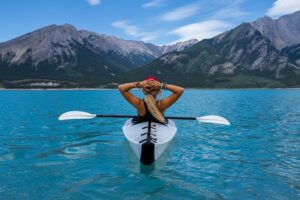 Kayaking woman taking a break on a lake to finish what she started and end the trip